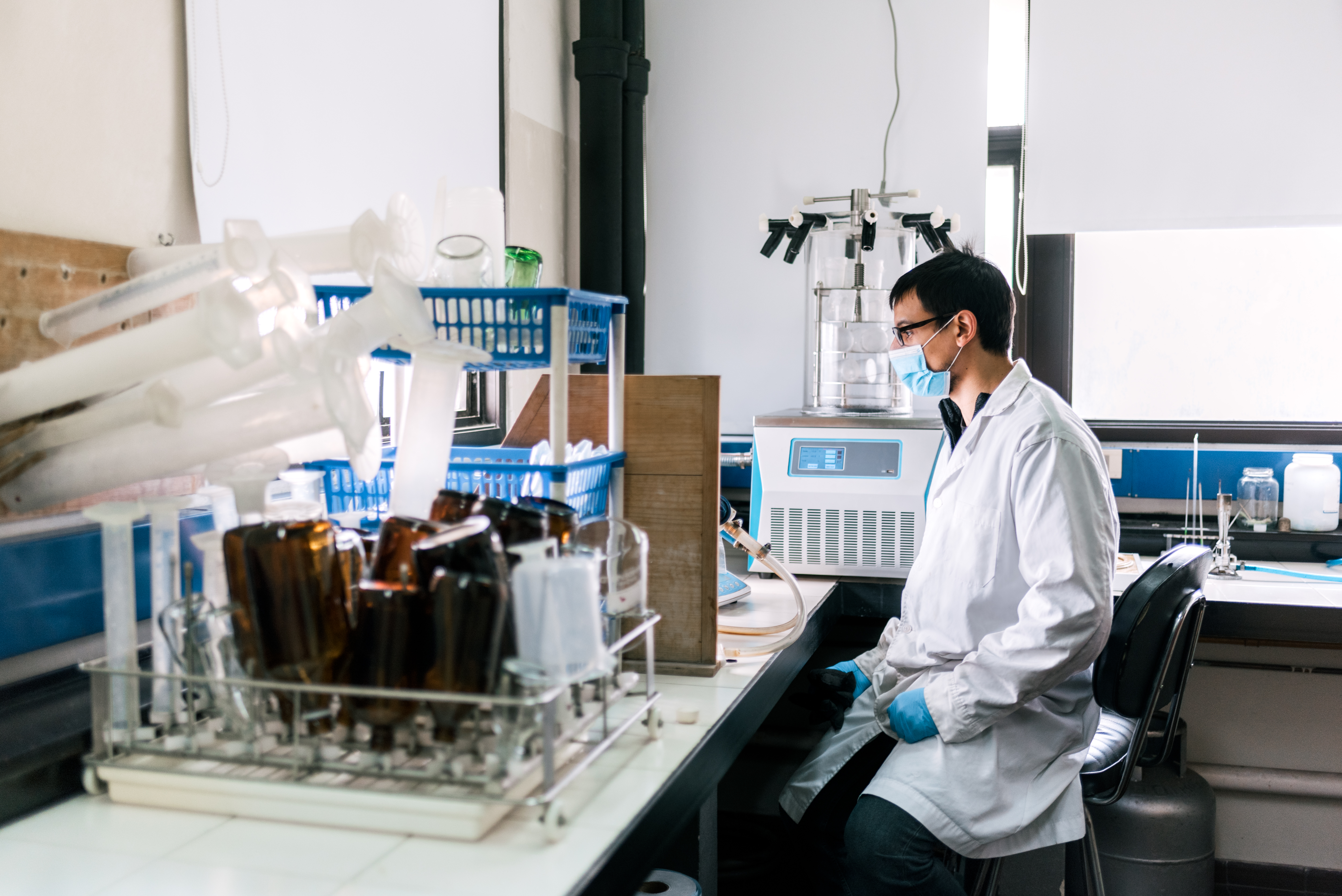 Stock photo of male scientist wearing face mask working in his laboratory.
