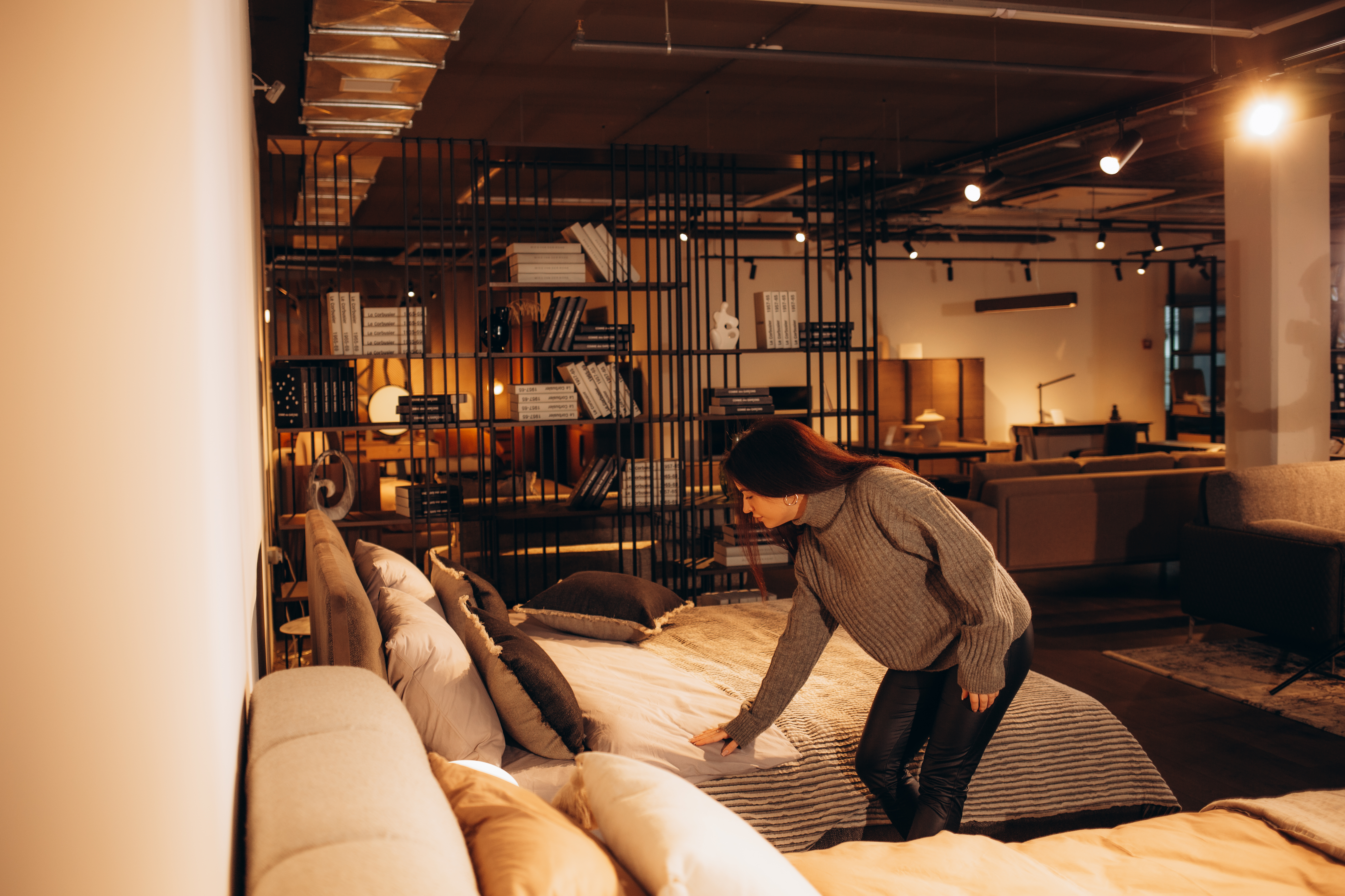 Happy woman smiling while looking to buy a new bedroom furniture at the showroom. High quality photo